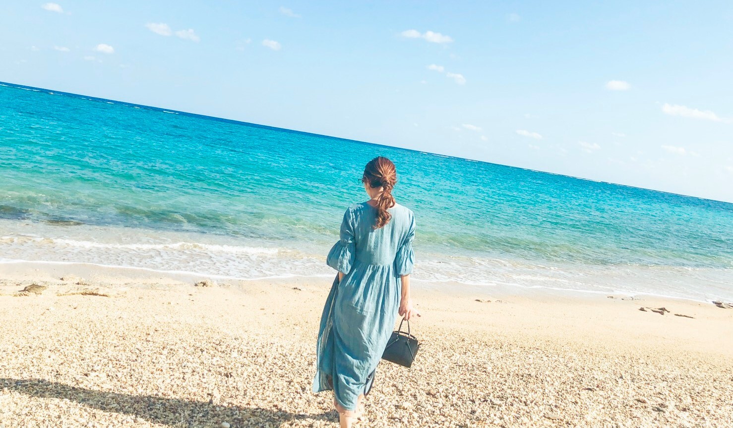 崖の上から見渡す穴場ビーチで写真撮影